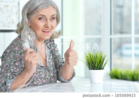Portrait of old woman with flu inhalation showing thumb up 105089915