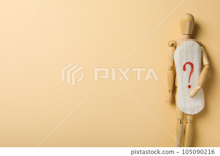 Menstrual cycle concept, wooden figurine of a man holding a pad 105090216