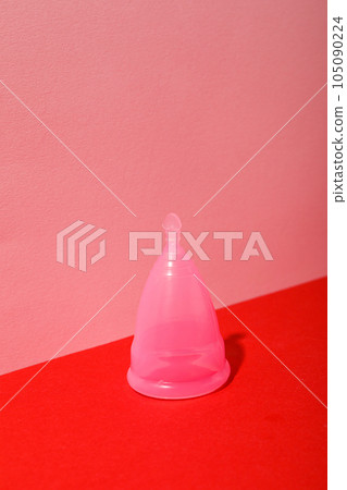 Menstrual cup on pink with red background Menstrual cup on pink with red background 105090224