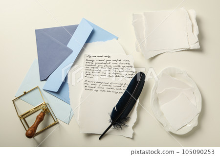 Blue envelopes, sheets of paper, bird feather and letter with text on white background, top view Blue envelopes, sheets of paper, bird feather and letter with text on white background, top view 105090253