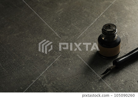 Ink bottle and pen on gray background, space for text Ink bottle and pen on gray background, space for text 105090260