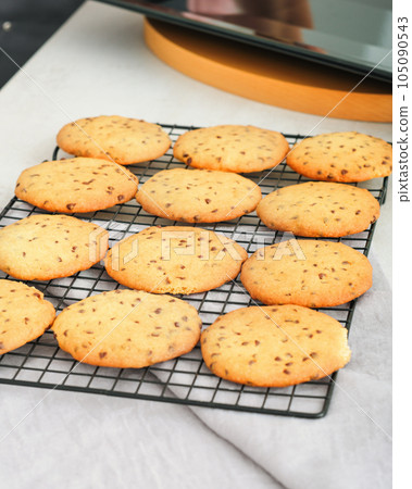 crispy orange and chocolale cookies cool on a rack. ready baked cookies with chocolate chips. Comforting meal. vertical shot. crispy orange and chocolale cookies cool on a rack. ready baked cookies with chocolate chips. Comforting meal. vertical shot. 105090543
