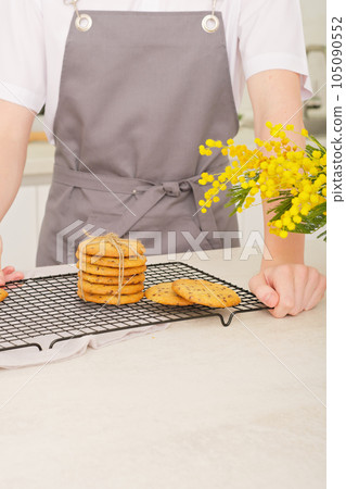 stack of classic round bisquits on a kitchen rack. crispy cookies made by teenager boy in apron. teen guy showing his own pastry ready to eat. stack of classic round bisquits on a kitchen rack. crispy cookies made by teenager boy in apron. teen guy showing his own pastry ready to eat. 105090552
