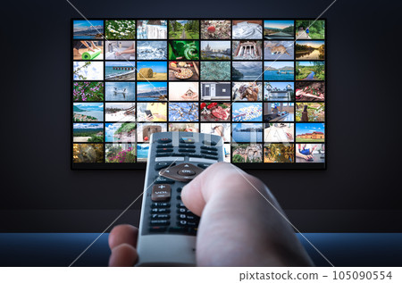 Streaming service. TV screen with lot of pictures and hand holding TV remote control. Multimedia Television video streaming, Media TV on demand. Subscription Streaming video 105090554