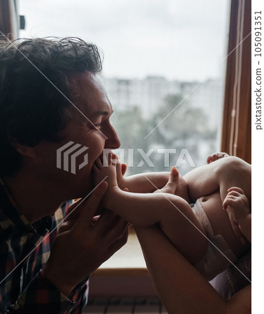 Mom and dad newborn. Caring and loving parents kiss the child on both cheeks. The concept of loving parents, the manifestation of emotions and a responsible attitude towards motherhood and fatherhood 105091351