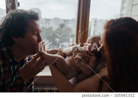 Mom and dad newborn. Caring and loving parents kiss the child on both cheeks. The concept of loving parents, the manifestation of emotions and a responsible attitude towards motherhood and fatherhood Mom and dad newborn. Caring and loving parents kiss the child on both cheeks. The concept of loving parents, the manifestation of emotions and a responsible attitude towards motherhood and fatherhood 105091352