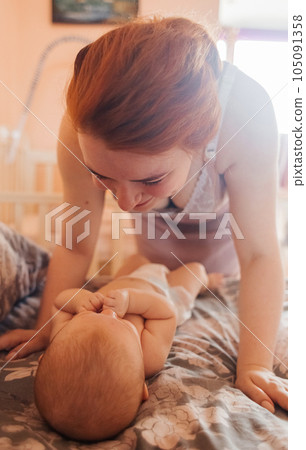 The young mother bent over the child. Hand in hand as a symbol of love for one offspring. Caring mother concept. Games with daughter. Natural parenting and caring for children The young mother bent over the child. Hand in hand as a symbol of love for one offspring. Caring mother concept. Games with daughter. Natural parenting and caring for children 105091358