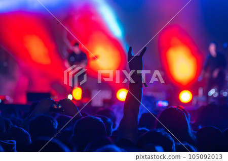Unrecognizable man showing rock gesture with hand to playing guitarist in concert on stage Unrecognizable man showing rock gesture with hand to playing guitarist in concert on stage 105092013