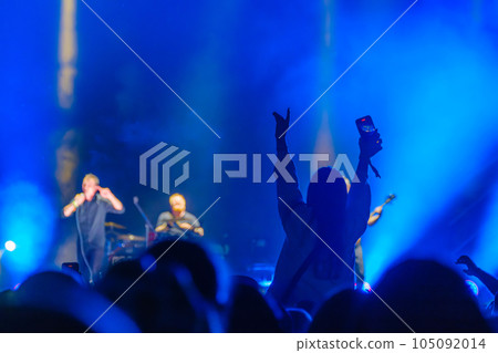 Unrecognizable spectator standing and showing hand to concert performers on stage in neon lights Unrecognizable spectator standing and showing hand to concert performers on stage in neon lights 105092014