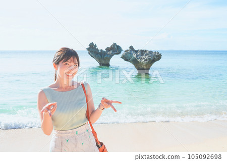 A woman sightseeing at Kouri Island Heart Rock in Okinawa 105092698