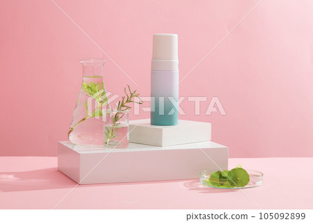 Against the pink background, a blank bottle container cosmetic placed on white podiums with glassware filled with seaweed leaves. Space for design, advertising and branding cosmetic product Against the pink background, a blank bottle container cosmetic placed on white podiums with glassware filled with seaweed leaves. Space for design, advertising and branding cosmetic product 105092899