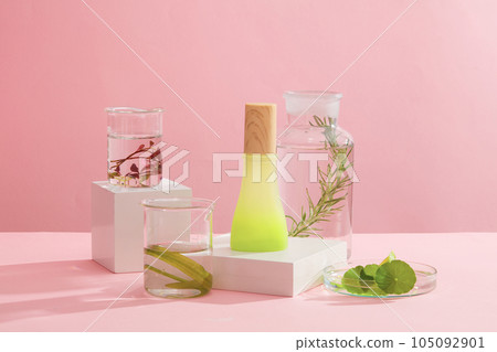 Minimalist creative background for cosmetics or products presentation. A green glass bottle placed on white podium decorated with flasks filled with different types of seaweed leaves Minimalist creative background for cosmetics or products presentation. A green glass bottle placed on white podium decorated with flasks filled with different types of seaweed leaves 105092901