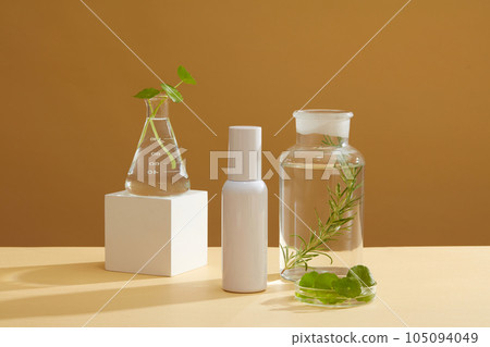 A conical flask, petri dish and a jar of centella leaves and seaweed arranged on brown background. Empty label bottle for cosmetic advertising of seaweed extract A conical flask, petri dish and a jar of centella leaves and seaweed arranged on brown background. Empty label bottle for cosmetic advertising of seaweed extract 105094049