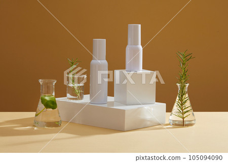 Two bottle without label standing on the podiums. A beaker and flask containing green seaweed. Empty label for cosmetic presentation of seaweed extract Two bottle without label standing on the podiums. A beaker and flask containing green seaweed. Empty label for cosmetic presentation of seaweed extract 105094090