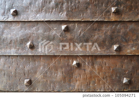 Background of metal surface from sheets with rivets, close-up. Texture of the iron gate. A metal relief backing for branding. Herceg Novi, Montenegro. Metal pimples. Gate of a fortress or castle Background of metal surface from sheets with rivets, close-up. Texture of the iron gate. A metal relief backing for branding. Herceg Novi, Montenegro. Metal pimples. Gate of a fortress or castle 105094271