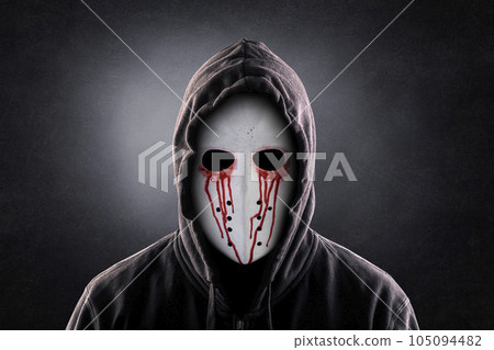 Spooky figure in blood with hooded cape over dark misty background 105094482