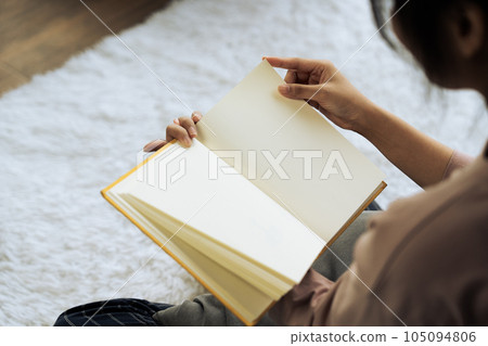 Closeup hand open book for reading in living room Closeup hand open book for reading in living room 105094806