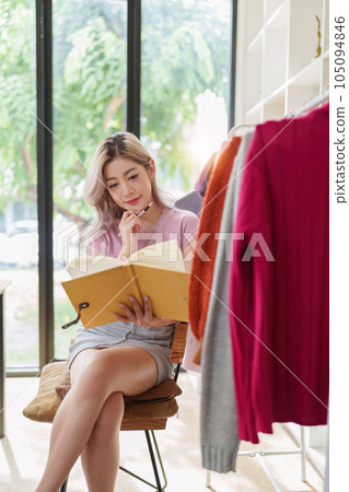 Asian female fashion designer sketches the design of a new dress in a fashion studio 105094846