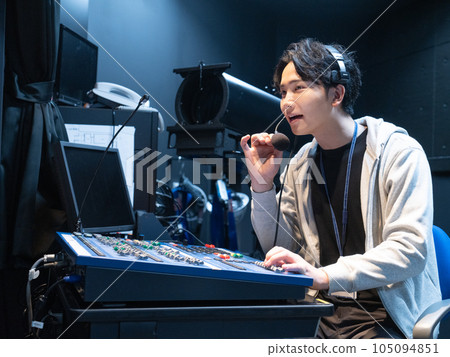 Young man adjusting lighting in hall lighting room Young man adjusting lighting in hall lighting room 105094851