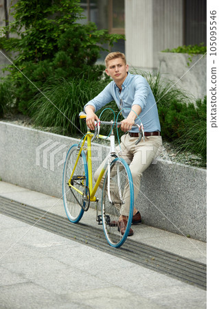Businessman, office worker wearing stylish smart casual clothes, sitting on street, outside the office with bike. Urban background 105095546