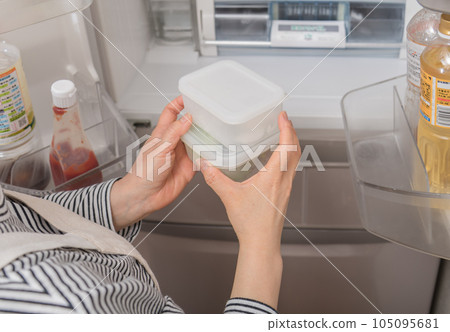 [A housewife taking out a tapper from the refrigerator] 105095681