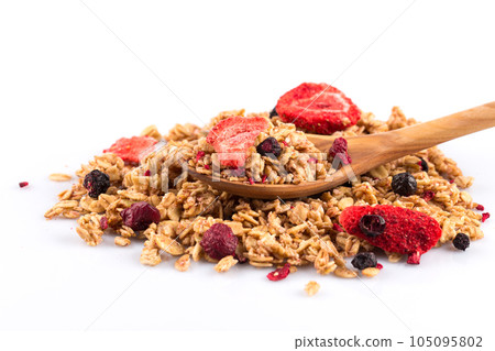 Muesli oat cereals close up background with dry fruits in wooden spoon 105095802