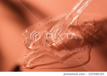 Beauty face serum gel with dropper. Transparent skincare cream with bubbles on coral background. 105096165