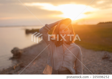 Young woman walking near lake, enjoying summer time. 105096252
