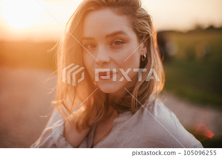 Portrait of young woman walking near lake, enjoying summer time. 105096255