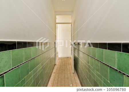 a long hallway with green tiles on the walls and wood flooring in an apartment building, taken from above a long hallway with green tiles on the walls and wood flooring in an apartment building, taken from above 105096780