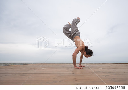 Caucasian man with naked torso practicing wushu on the seashore. Caucasian man with naked torso practicing wushu on the seashore. 105097366