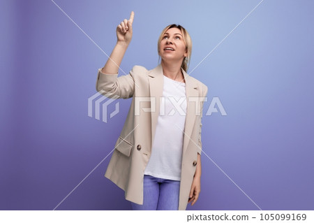 close-up of a blonde business woman in a jacket pointing her finger on a blue background with copy 105099169