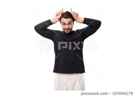 young brunette caucasian male model with a beard dressed in a black jacket makes a grimace 105099179
