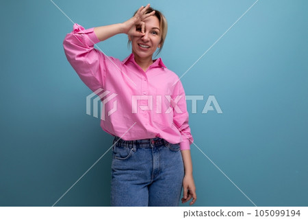 young smiling european blond office worker woman dressed in a pink shirt and jeans 105099194