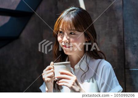 Woman drinking coffee in a sunny room Woman drinking coffee in a sunny room 105099206