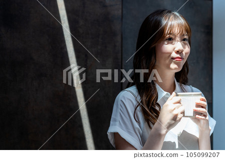 Woman drinking coffee in a sunny room 105099207