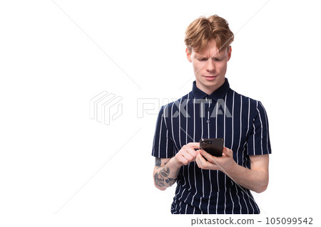25 year old blond man in a striped polo chatting on a smartphone 105099542