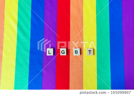 LGBT community, bright rainbow flag, wooden lettering. The rights of all people on the planet, hands in the frame, vertical photo. LGBT community, bright rainbow flag, wooden lettering. The rights of all people on the planet, hands in the frame, vertical photo. 105099907