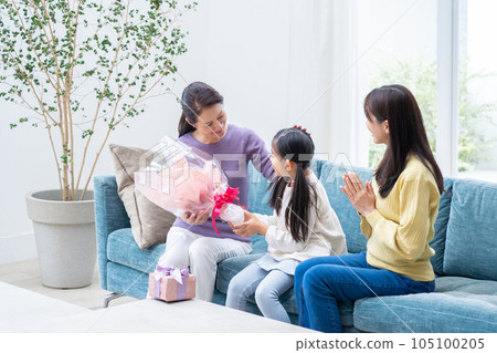 Granddaughter giving a present to grandma 105100205