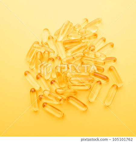 Top view of oil softgel capsules on yellow background. Nutritional supplement contains fish oil, omega 3, omega 6, omega 9, vitamin e, vitamin d and vitamin a. Top view of oil softgel capsules on yellow background. Nutritional supplement contains fish oil, omega 3, omega 6, omega 9, vitamin e, vitamin d and vitamin a. 105101762