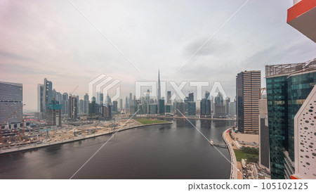 Aerial skyline of Dubai Business Bay and Downtown with the various skyscrapers and towers day to night timelapse 105102125