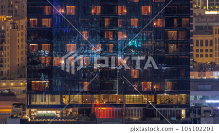 Office and residential buildings windows illuminated at night timelapse 105102201