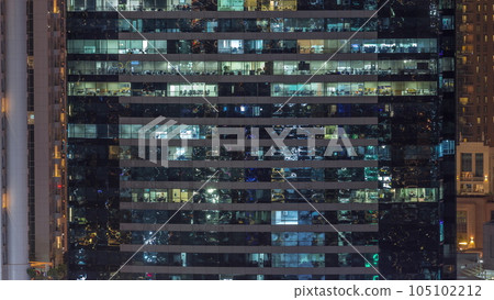 Office buildings windows illuminated at night timelapse 105102212