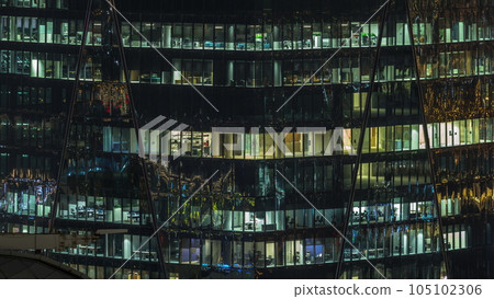 Frontal view of night facade of building with a lot of windows with light timelapse. Frontal view of night facade of building with a lot of windows with light timelapse. 105102306