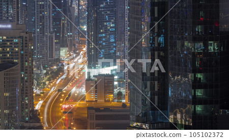 Aerial view from above to a busy road junction in Dubai all night timelapse. 105102372