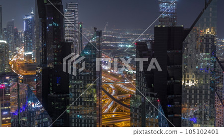 Aerial view from above to a busy road junction in Dubai night timelapse. Aerial view from above to a busy road junction in Dubai night timelapse. 105102401