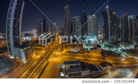 Aerial panorama of Dubai Downtown skyline with many towers night to day timelapse. 105102449