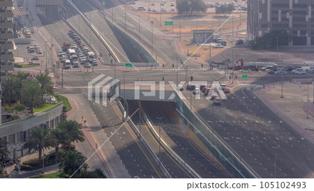 Top aerial view of busy road intersection and traffic junctions in Dubai city timelapse. Top aerial view of busy road intersection and traffic junctions in Dubai city timelapse. 105102493