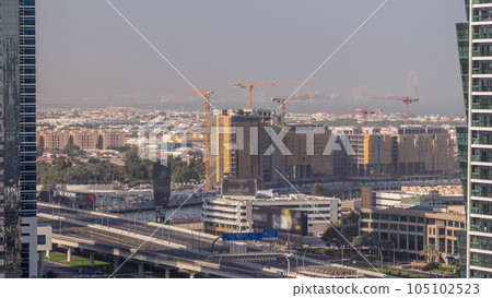 Construction site around Dubai water canal with many cranes aerial timelapse. 105102523
