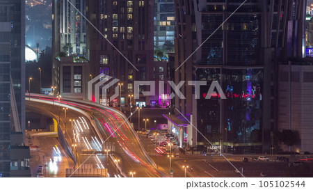 Top aerial view of busy road intersection and traffic junctions in Dubai city night timelapse. 105102544